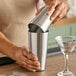 A person pouring a cocktail from an American Metalcraft Weighted Boston Shaker.