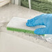A gloved hand cleaning a counter with a Lavex sponge.