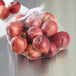 A close-up of apples in a Royal Paper clear plastic mesh bag.