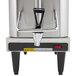A Grindmaster stainless steel coffee brewer with a handle.