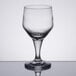 A close-up of a Libbey clear wine glass on a reflective surface.