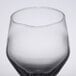 A close up of a clear Libbey Estate wine glass with a small amount of water in it.