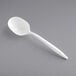 A white plastic spoon on a gray surface.