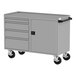 A grey metal workbench with four drawers and a door.