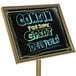A black Aarco marker board with brass frame on a deli counter with a sign that says "Come for some great delivery" in neon.