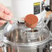 A person using a Globe countertop mixer to mix brown powder.