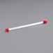 A white tube with red corners and a red handle.