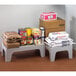 A stack of boxes and bags on a Cambro slotted top dunnage rack.