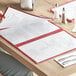A person reading a burgundy Choice trifold menu at a restaurant.