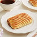 A close up of a Bridor Ready to Bake Chocolate Avalanche pastry on a white plate.