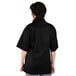 A woman wearing a black Uncommon Chef Tingo short sleeve chef coat.