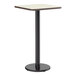 A square bar height table with a reversible white birch or ash laminated top and a black cast iron base.