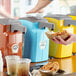 A person using a Heinz pump to add condiments to a tray of food.