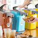 A person pouring Heinz Ranch from a pump dispenser into a bowl of food.