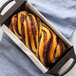 Lodge cast iron loaf pan with a loaf of bread.