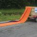 A Quick Dam Water Barrier on a trailer being towed on a road.