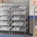A Regency stationary metal shelving unit with clear bins on it.