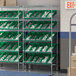 A Regency stationary chrome shelf unit with green bins on it.
