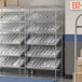 A Regency stationary metal shelving unit with clear plastic bins on the shelves.