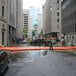 A man walking in a flooded street next to a black truck with Quick Dam flood barriers in place.