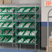 A Regency stationary chrome shelf unit with green bins on the shelves.