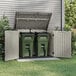 A green Suncast horizontal storage shed with two open trash cans inside.