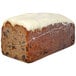 A loaf of Sweet Sam's carrot walnut pound cake with cream cheese icing on top.