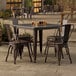 A Lancaster Table & Seating outdoor table with four chairs on a patio.