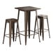 A Lancaster Table & Seating bar height table with brown metal legs and two backless barstools with brown seats.