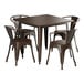 A brown metal Lancaster Table & Seating outdoor table with four arm chairs.