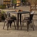 A Lancaster Table & Seating outdoor table and chairs on a patio.