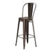 A brown metal bar stool with a backrest on a copper table.