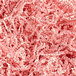 A close-up of a pile of Spring-Fill light pink crinkle cut paper shred.