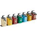 A white and grey Heinz Keystone condiment pump dispenser set with yellow, blue, green, and red containers with silver lids and handles.