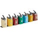 A row of yellow, grey, and white Heinz condiment dispensers with black lids.