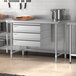 A Regency stainless steel work table in a professional kitchen.