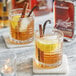 A close-up of two glasses of brown liquid with cinnamon sticks.