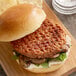 A Beyond Meat plant-based burger on a wooden cutting board.