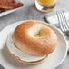 A plain bagel with cream cheese on a plate.