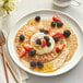 A plate of pancakes topped with strawberries and whipped cream.