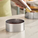 A 4-inch round stainless steel mousse ring used for baking or molding desserts.