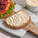 A sandwich with a white spread on it made with Green Oasis Vegan Mayonnaise.