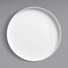 A Oneida Scandi bright white porcelain plate with a raised rim on a gray surface.