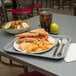 A Carlisle fast food tray with sandwiches, salad, and a drink.