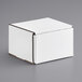 A white box with a lid on a gray surface.