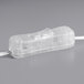 A close up of a clear plastic neon light with wires attached on a white background.