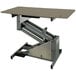 A tan Groomer's Best electric grooming table with a metal frame.