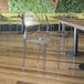 A table with a Flash Furniture Revna transparent resin stackable chairs.