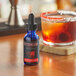 A blue bottle of Bittercube Cherry Bark Vanilla Bitters on a table in a cocktail bar.