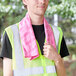 A man wearing a safety vest holding a pink Cordova Cooling Towel